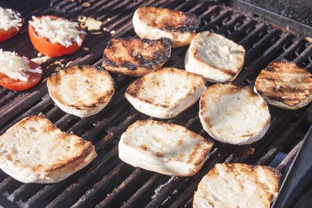 A barbeque full of tomatoes and grilled breadの写真素材