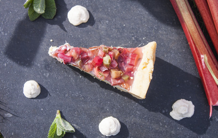 A slice of a rhubarb cake, between pannacotta and mintの写真素材