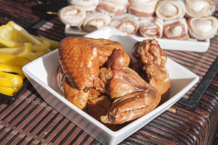 A white bowl, full of smoked chicken, between champignons and yellow pepperの写真素材