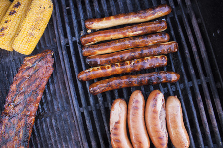 Grilled bratwursts, near pork loin ribs, sweet corn and sausage