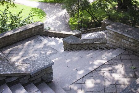 Stairs made of stone, heading down to a parkの写真素材