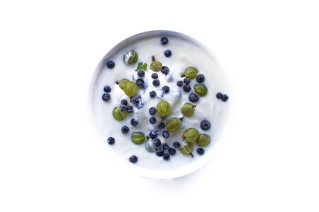 Gooseberries ribes uva-crispa, blueberries vaccinium myrtillus and yogurt, isolated on white backgroundの写真素材