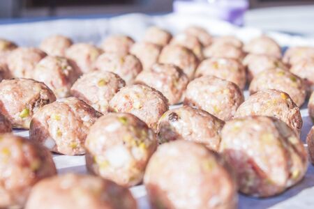 A lot of raw meatballs, on a plateの写真素材