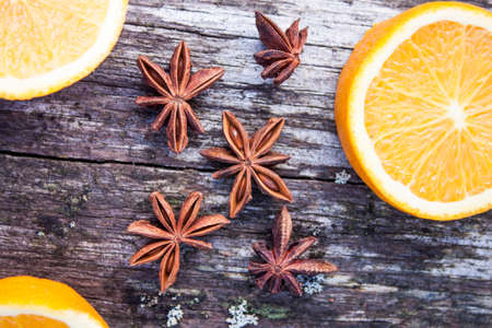 Star anise, Pimpinella anisum, between oranges, on wooden backgroundの写真素材