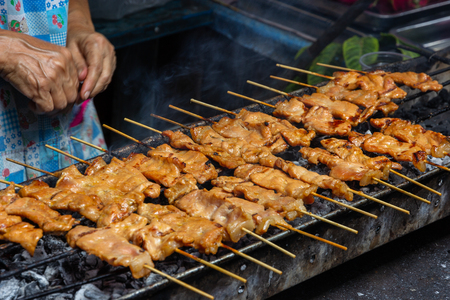 moo ping, grilled pork  skewer sticks on the bbq grill outdoor, Thai street foodの写真素材