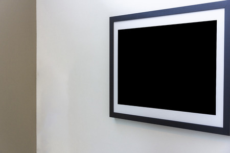 Blank photo frame on White wall in art gallery.