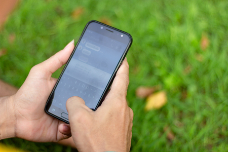Asian man holding smartphone in his hands and chatting message on the screen, communication