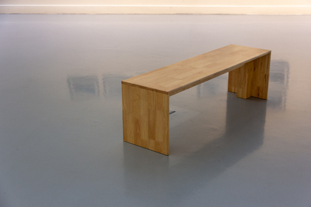 A bench for sitting and looking at painting in art gallery.