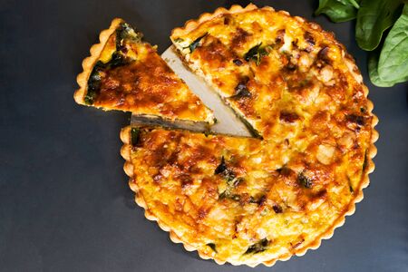 top view freshly bake leek bacon spinach quiche on dark backgroundの写真素材