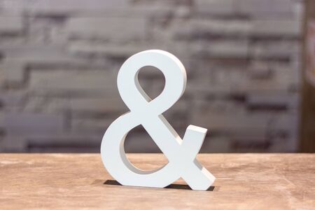 ampersand & sign on wood table with blurred wall backgroundの写真素材