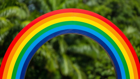 Title: showing title: vibrant rainbow arch over green leafy background in soft focus. resolution use.の素材