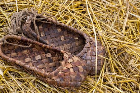 Bast shoes on the straw, traditional wicker shoes of ancient Russia. Close up shotの写真素材