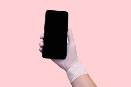 hand in a medical glove holds a smartphone