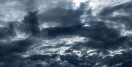 dramatic sky with flying dark clouds, overcast sky before a rainの写真素材