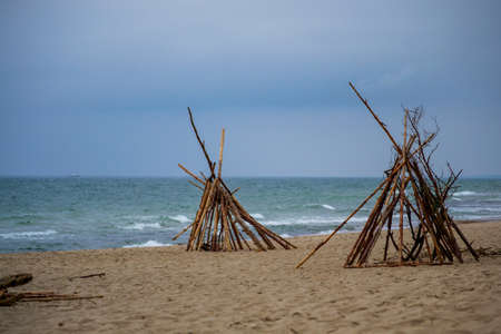 teepees collected from the wood thrown on the seashoreの写真素材