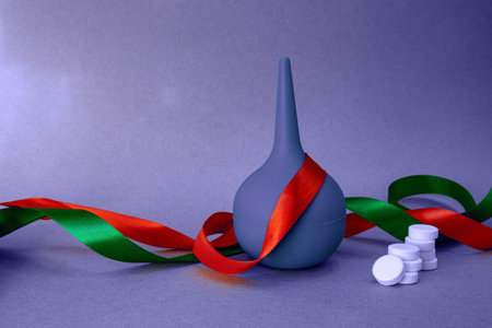 medical holiday background with ribbons, rubber bulb syringe and white tabletsの写真素材