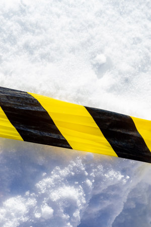 Warning tape stretched across fresh snowの写真素材