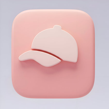 A pink square icon with a white baseball cap design. The icon is three-dimensional and has a soft, rounded appearance. The background is a light gray.の素材