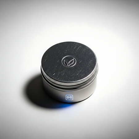 A closed round metal container or jar with a screw lid featuring an embossed leaf logo. The silver tin sits on a clean white surface casting a soft shadow.の素材