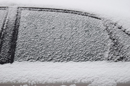 Car body part covered with white snow while still snowing in Medias, Romania.の写真素材