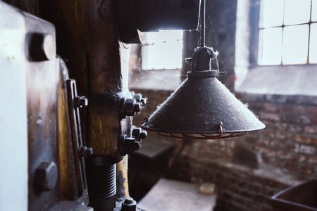 Machinery and lamp in old factoryの写真素材