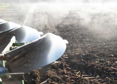 Plow in autumn, field with fog