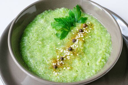 Summer cream soup made from broccoli. Green vegetable cream soup on a white backgroundの写真素材