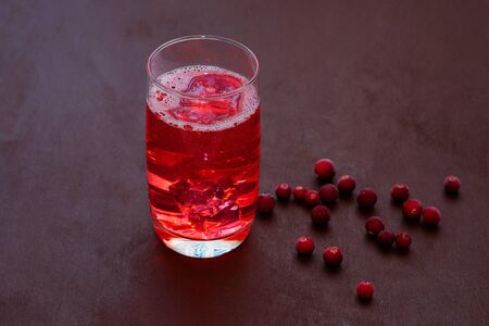 Cold summer drink. Sparkling glasses with berry cocktail. A glass of soda drink cranberries on a dark background.の写真素材