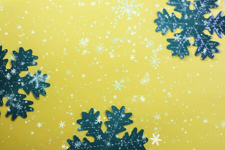 Snowflakes on a yellow background. Festive background. Holiday concept. Christmas and New Year concept. Top view, flat lay.の写真素材