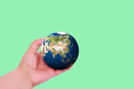 Planet earth in hand on a colored background with place for text. Earth day concept. Ecological...
