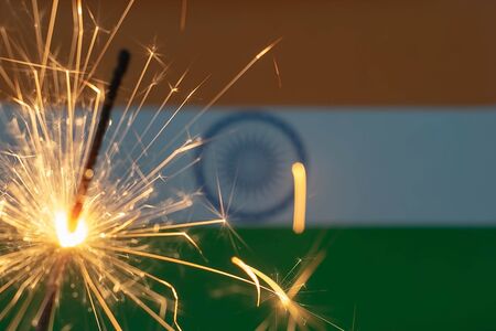 Sparkler over the Indian flag close-up. Independence Day. The concept of celebration, patriotism and...
