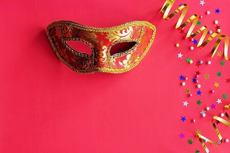Festive mask with decor on a red background. Carnival celebration concept, Mardi Gras, Brazilian...