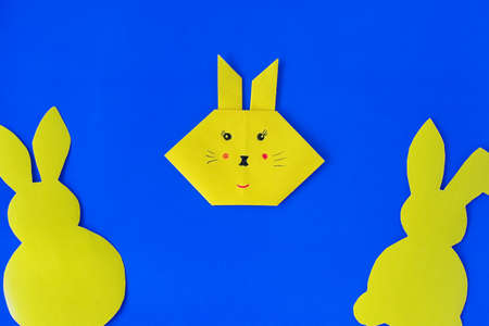How to make a bunny at home. Craft for Easter. Step-by-step instruction. Step 8. Take colored paper. A simple creative idea with your own hands. DIY children's art project.の写真素材