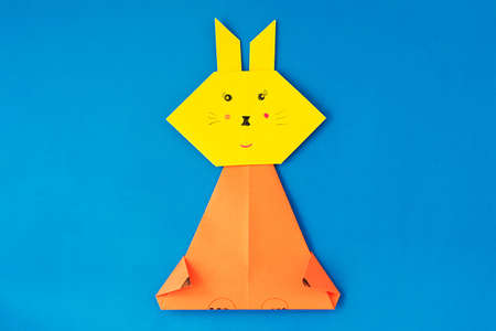 How to make a bunny at home. Craft for Easter. Step-by-step instruction. Step 6. Take colored paper. A simple creative idea with your own hands. DIY children's art project.の写真素材