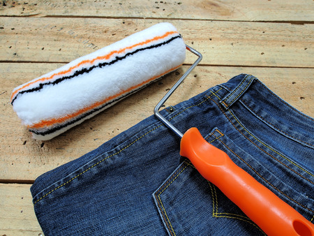 Paint roller and Jeans on wooden backgroundの写真素材