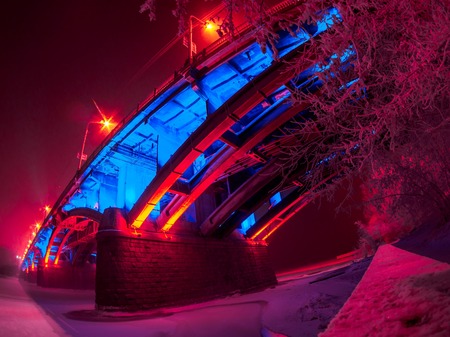Communal bridge over the Yenisei river in winter with beautiful illumination. On the street frost and the coldness.の写真素材