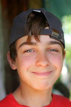 smiling young and happy boy portret in the capの写真素材