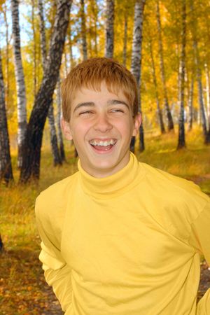 laughing boy stand in autumn forestの写真素材