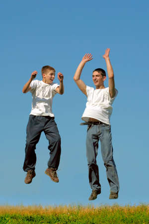 Happy smiling youth two tennage boys jumpingの写真素材