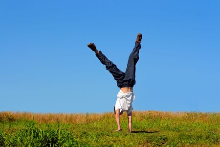 Somersault on grass on the blue sky backgroundの写真素材