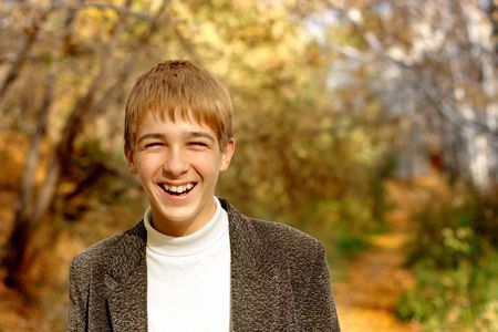 laughing boy stand in autumn forestの写真素材