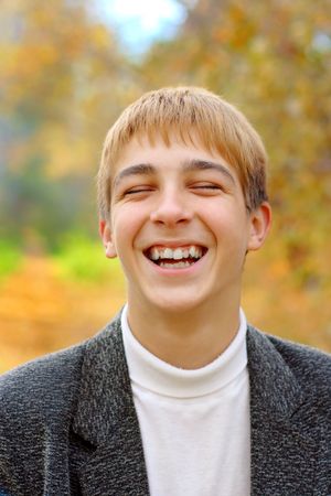laughing boy stand in autumn forestの写真素材