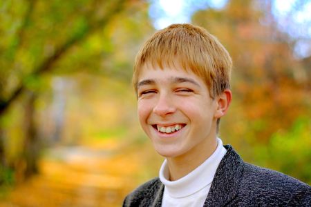 smiling teenager stand in autumn parkの写真素材