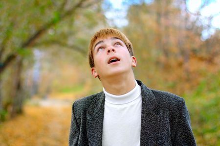 teenager looking upwards in the autumn park