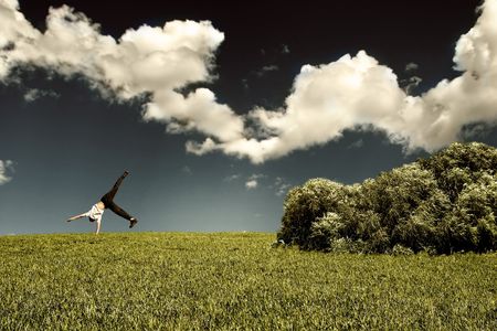 Somersault on grass on the blue sky backgroundの写真素材
