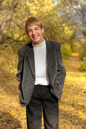 laughing boy stand in autumn forestの写真素材