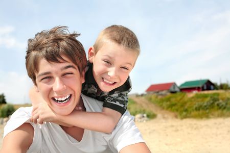 happy teenager and kid on the beachの写真素材