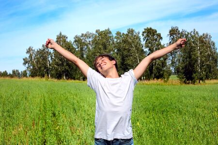 happy teenager stand on the summer fieldの写真素材