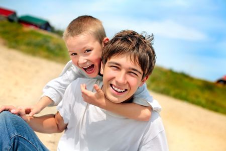 happy teenager and kid on the beachの写真素材