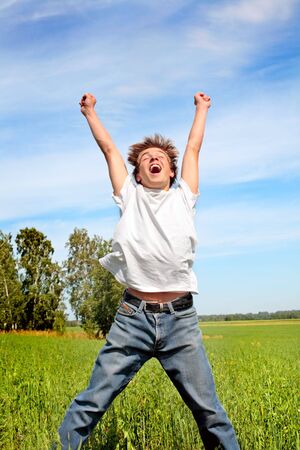 Happy teenager jumping on the meadowの写真素材